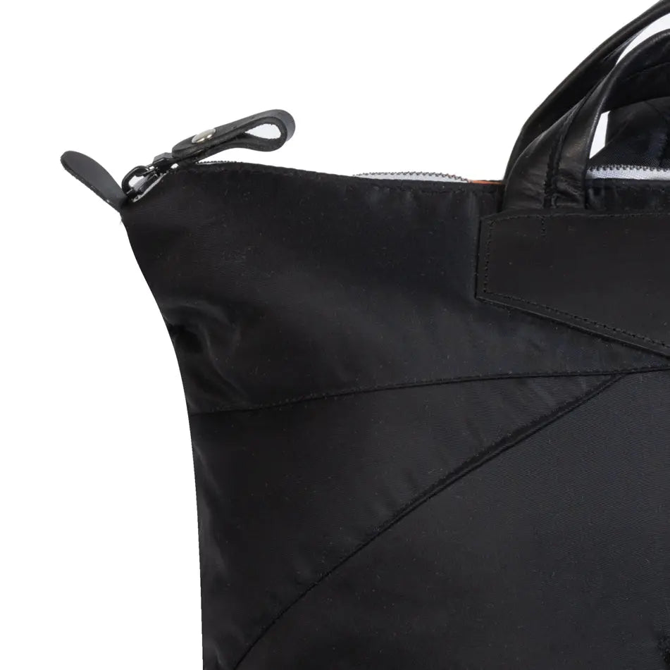 Close-up of a black tote bag with a zipper on a white background