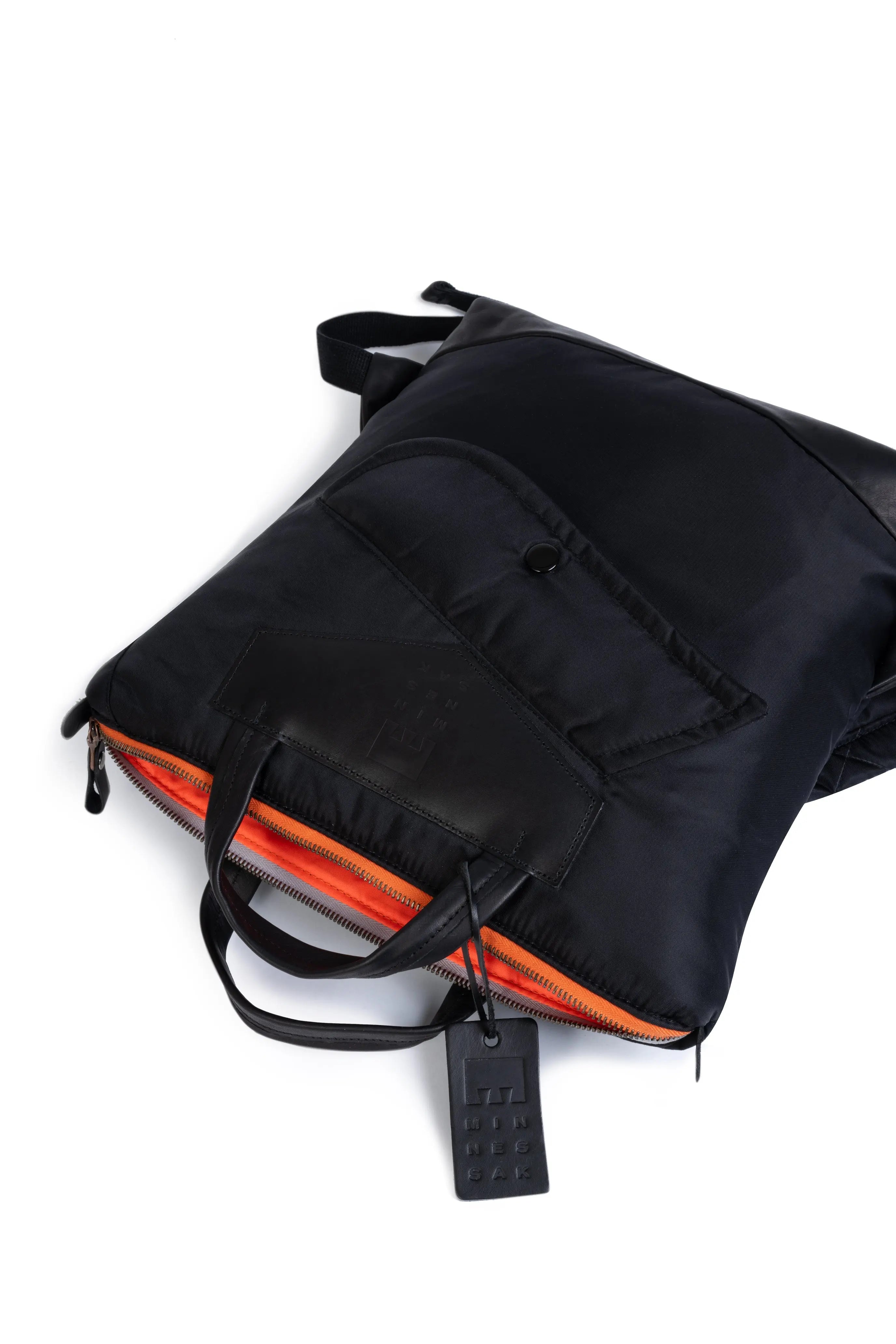 Black backpack with orange interior on a white background