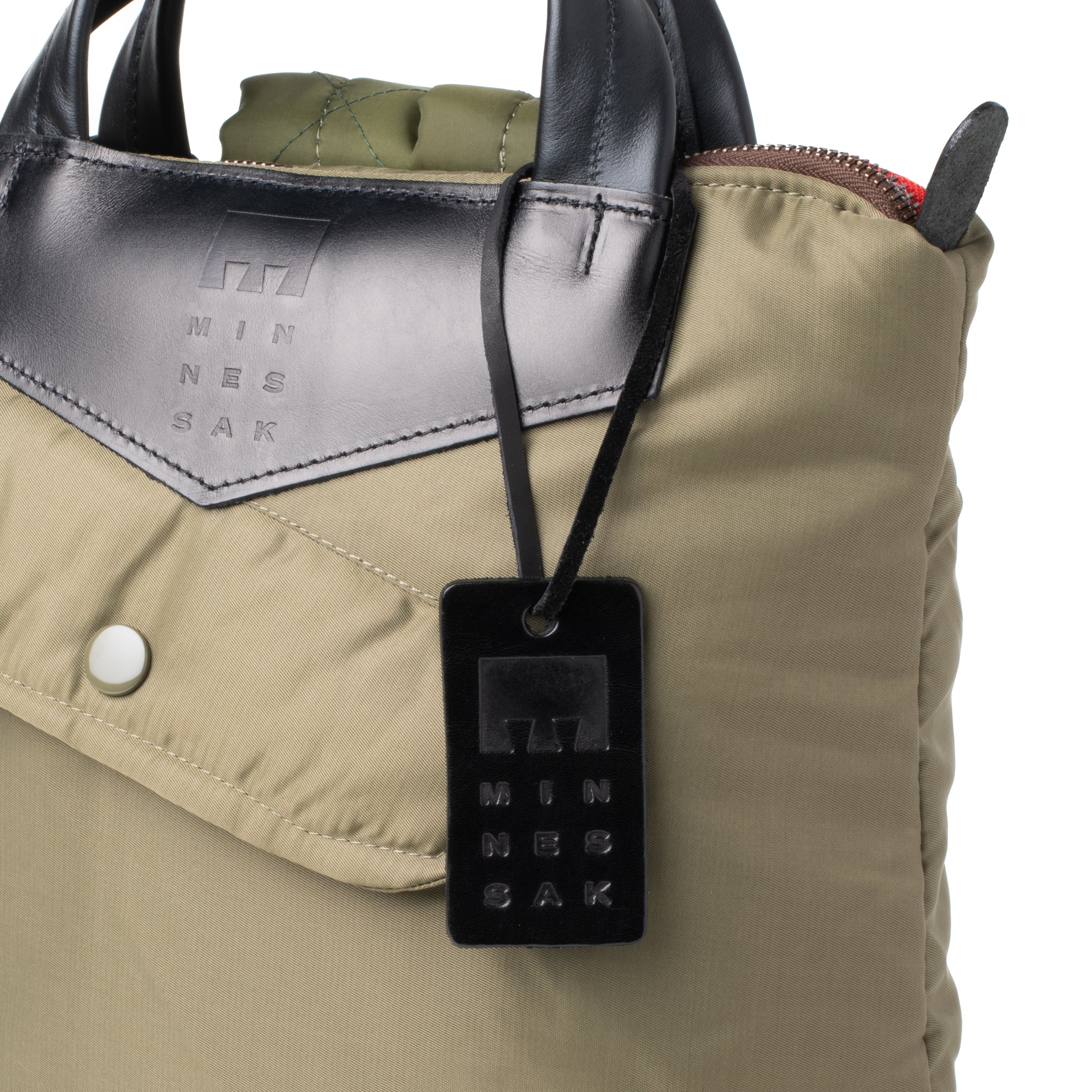 Olive bag with a black security tag featuring 'MINNESAK' branding.