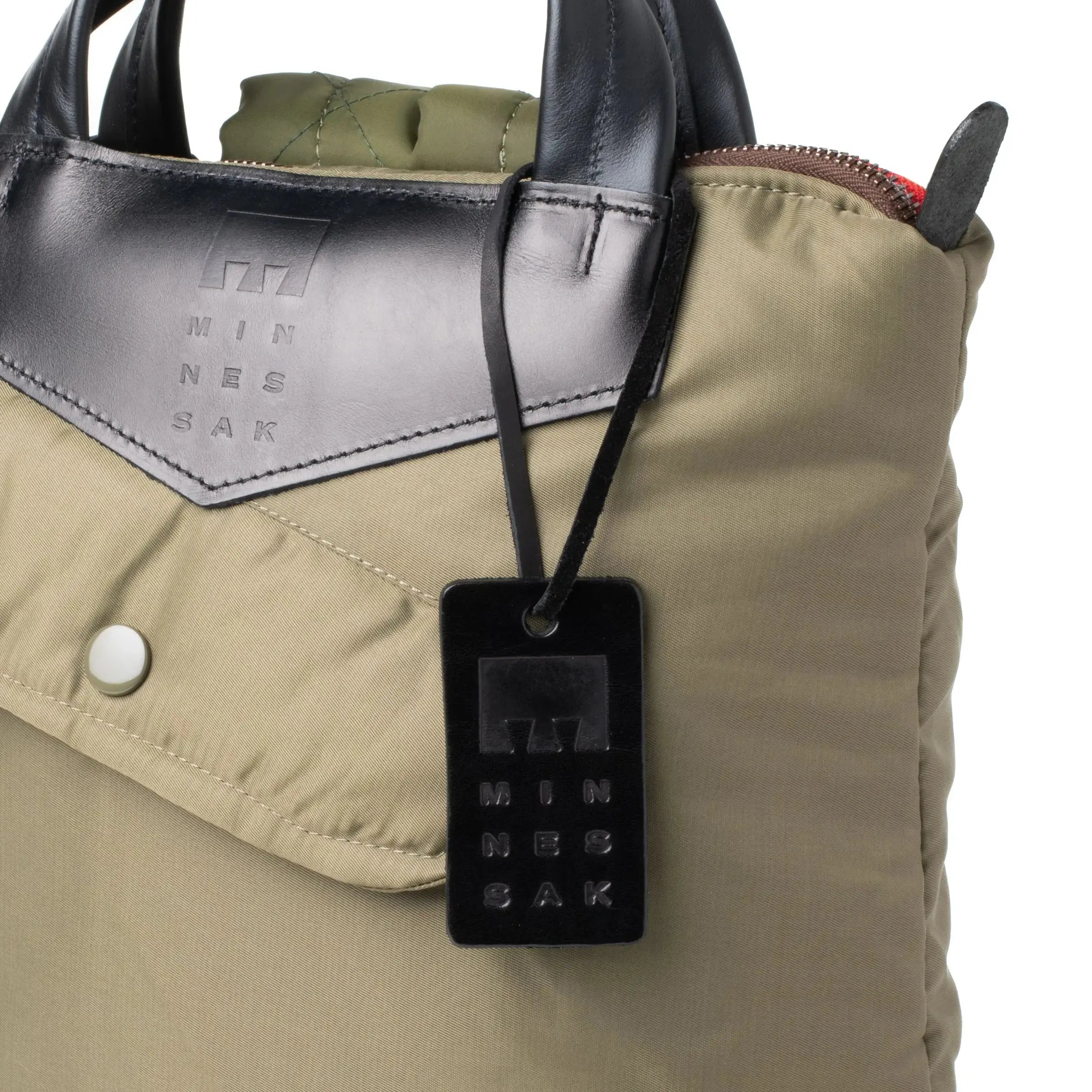 Olive bag with a black security tag featuring 'MINNESAK' branding.