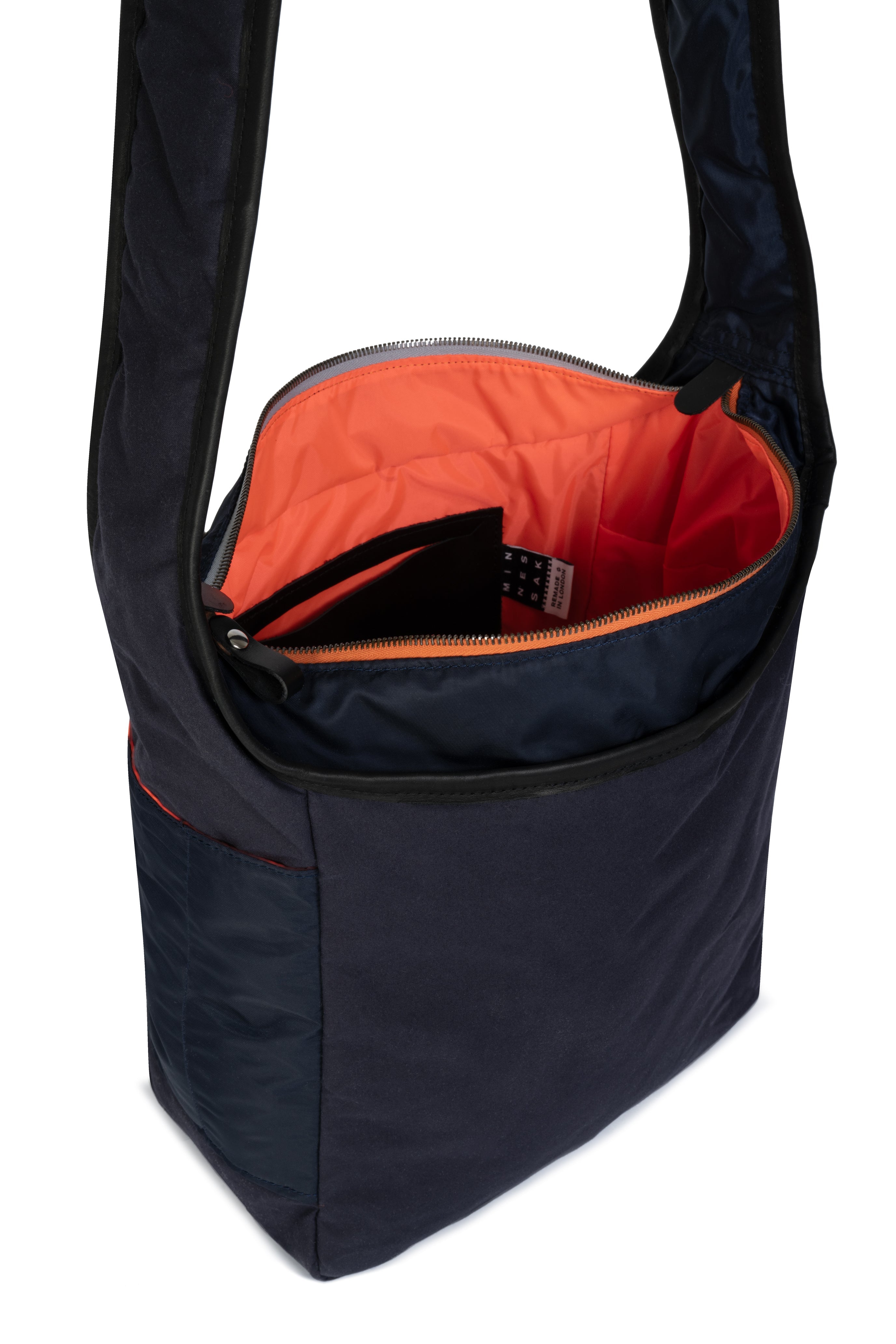 Navy shoulder bag with orange interior on a white background