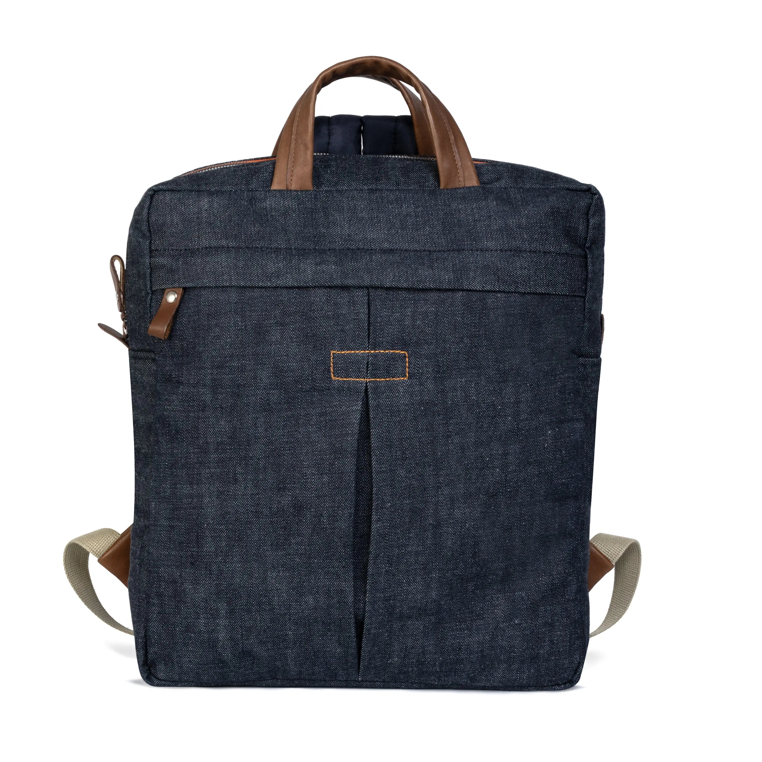 Blue denim backpack with brown leather straps on a white background