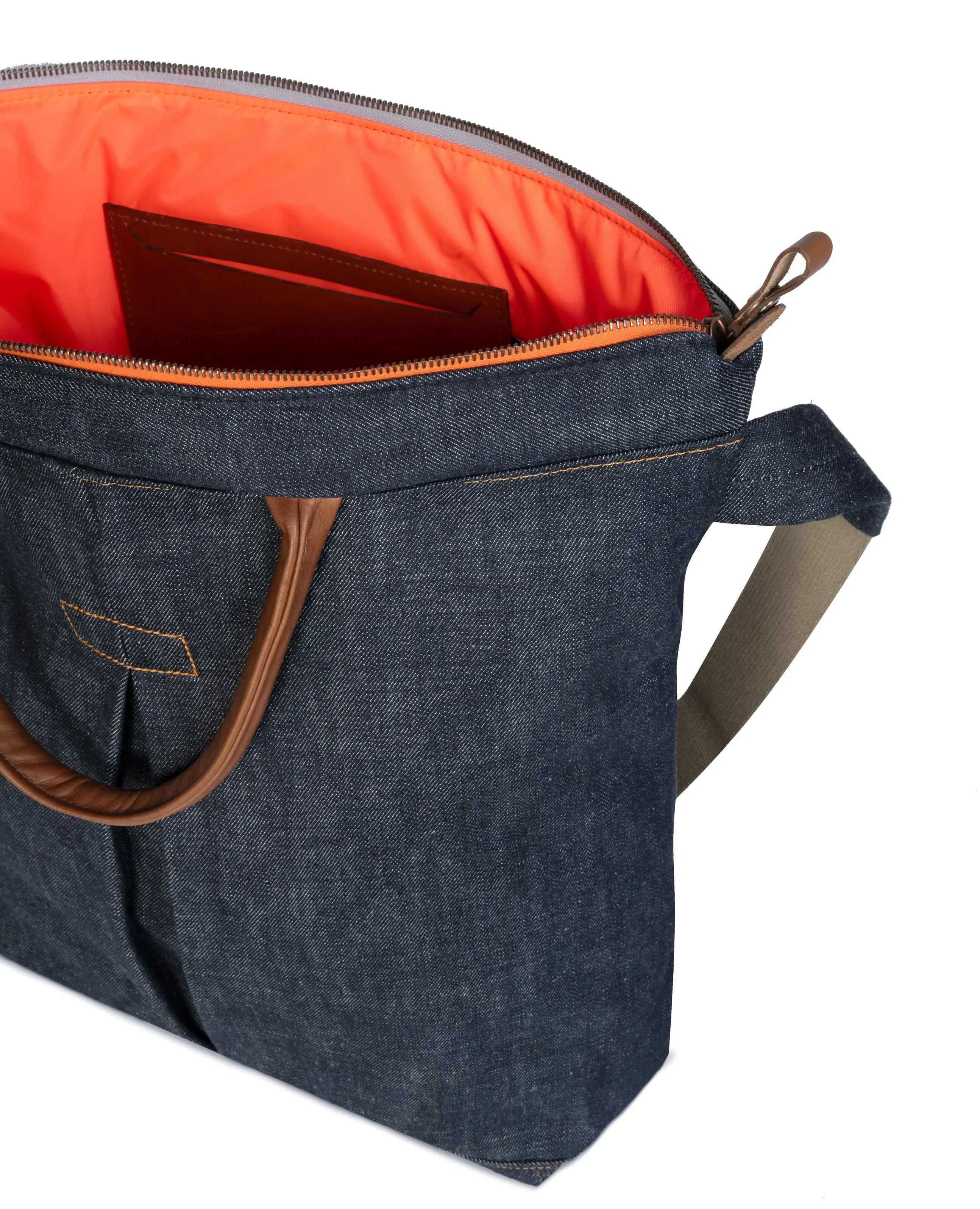 Blue denim bag with brown handles and orange interior on a white background