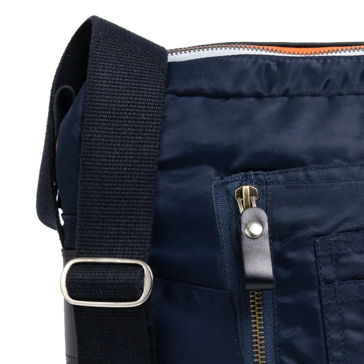 Close-up of a navy blue bag with a black strap and zipper detail.