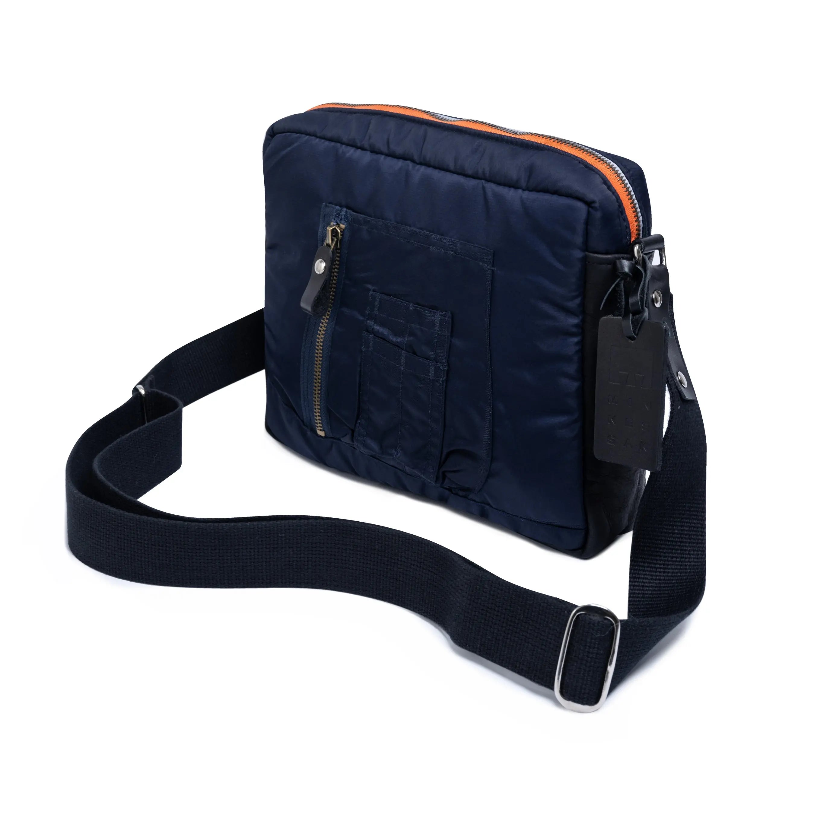 Navy blue shoulder bag with orange interior lining on a white background