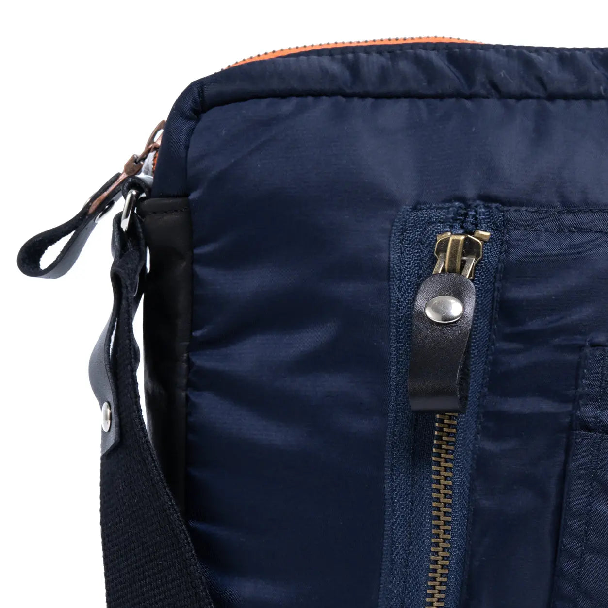 Close-up of a navy blue bag with a zipper and strap on a white background