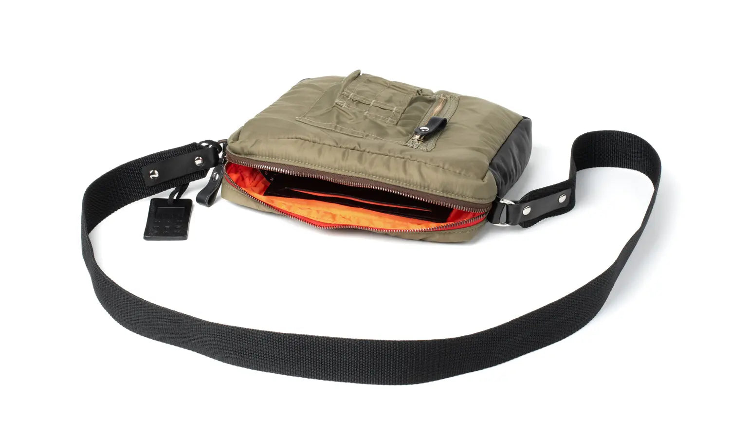 Olive shoulder bag showing orange lining with a black strap on a white background