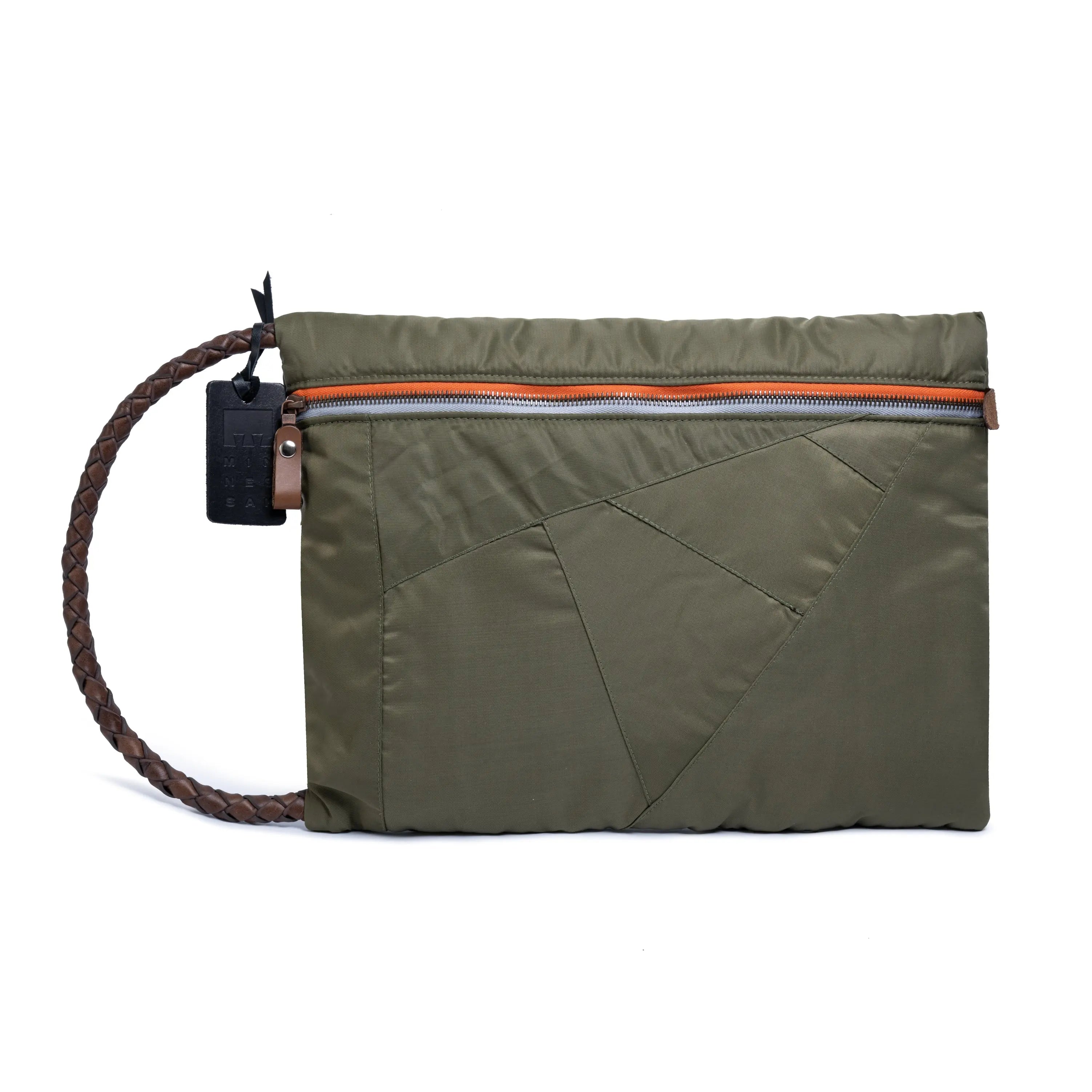 Olive pouch with orange zipper and a strapped crossbody on a white background