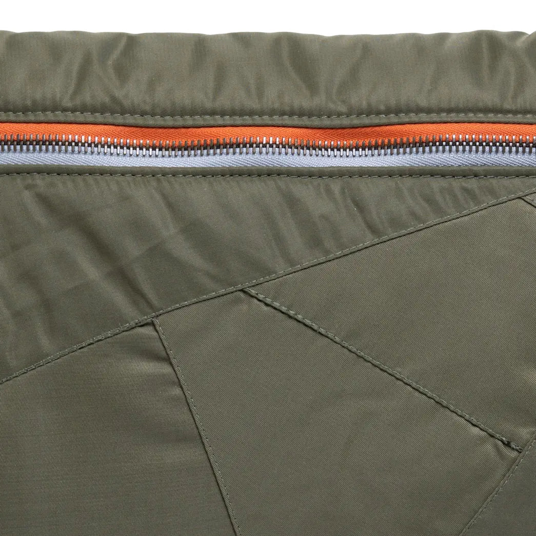 Close-up of a green jacket with an orange zipper