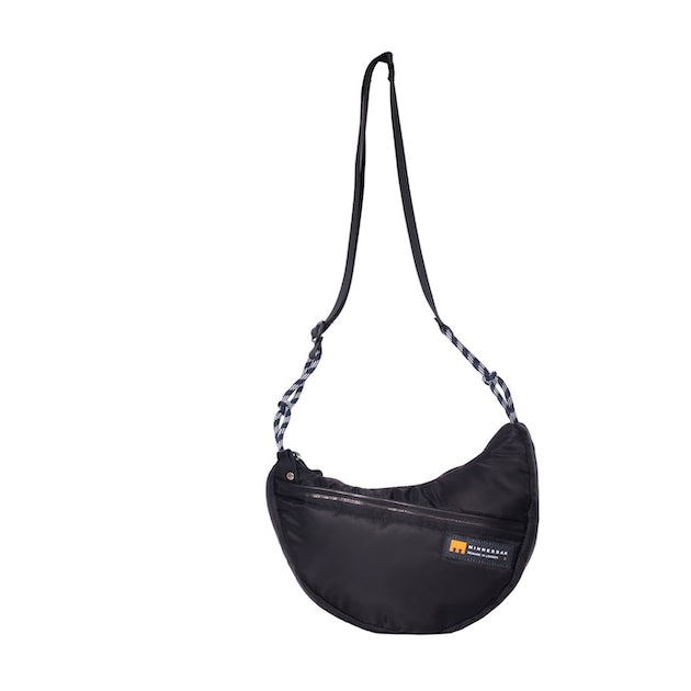 Black Boat Small sustainable crescent crossbody bag handmade from repurposed MA-1 flight jacket material with adjustable shoulder strap and front zip pocket. Front