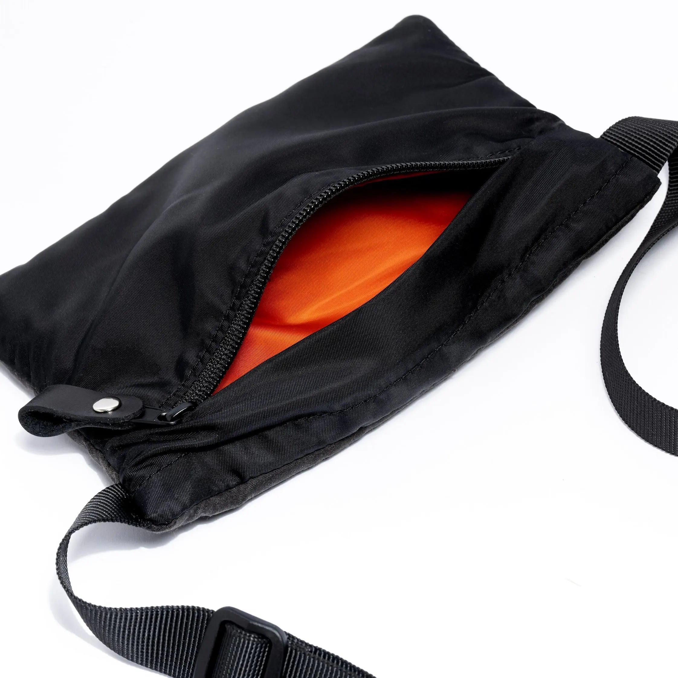 Small cross body bag in black showing internal detail on white background