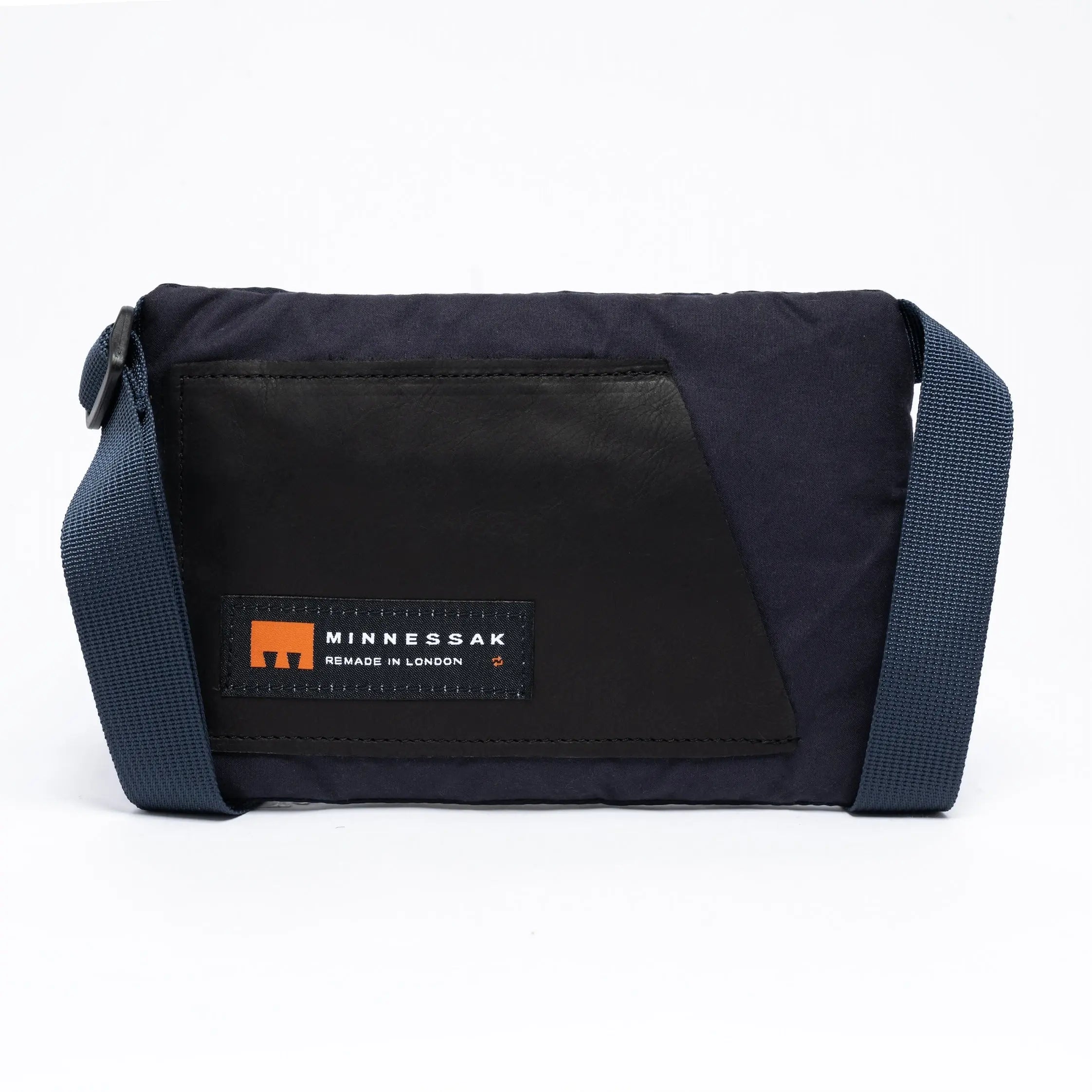 Small cross body bag in navy with straps and MInnessak logo on a white background