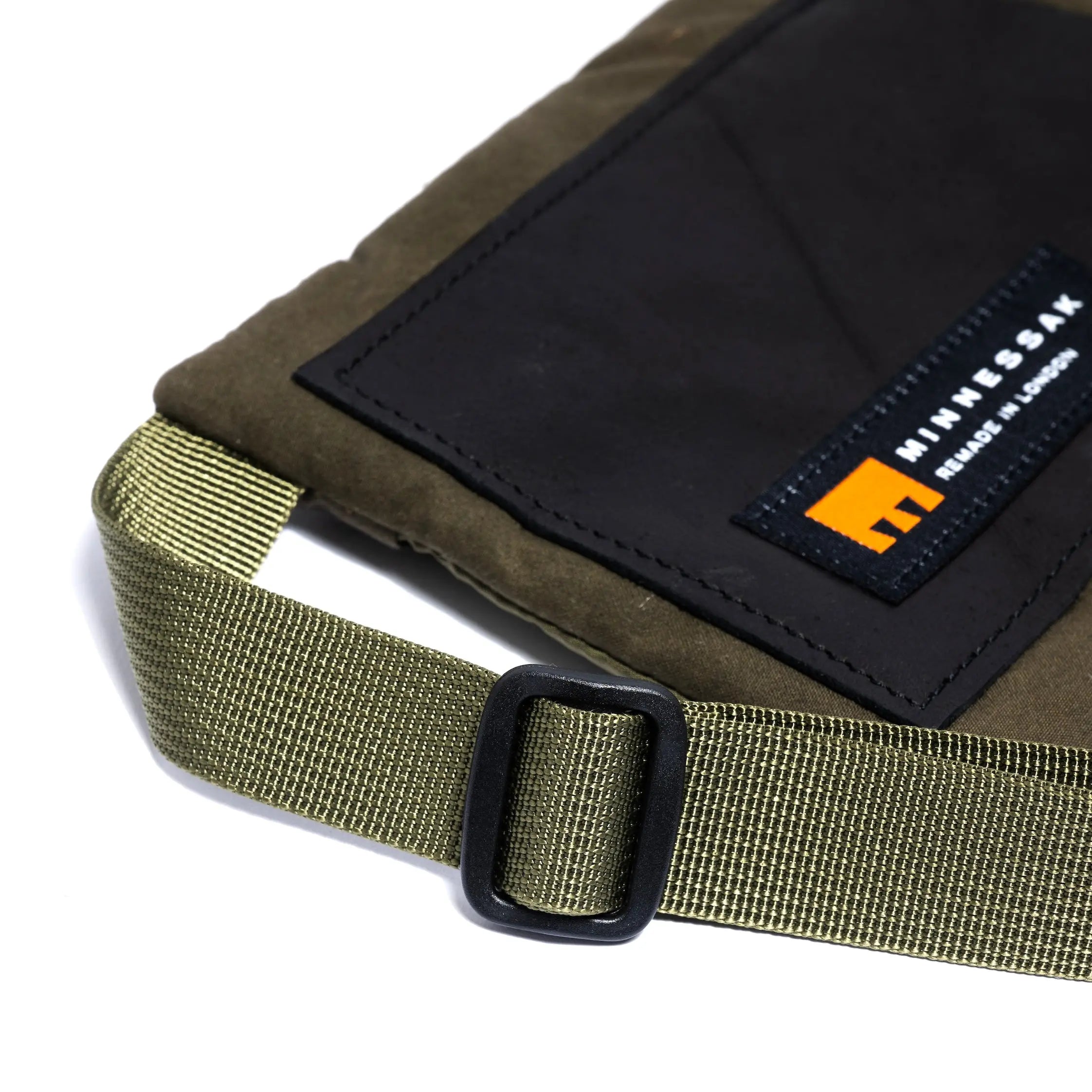 Olive cross body bag showing strap detail and MInnessak logo on a white background