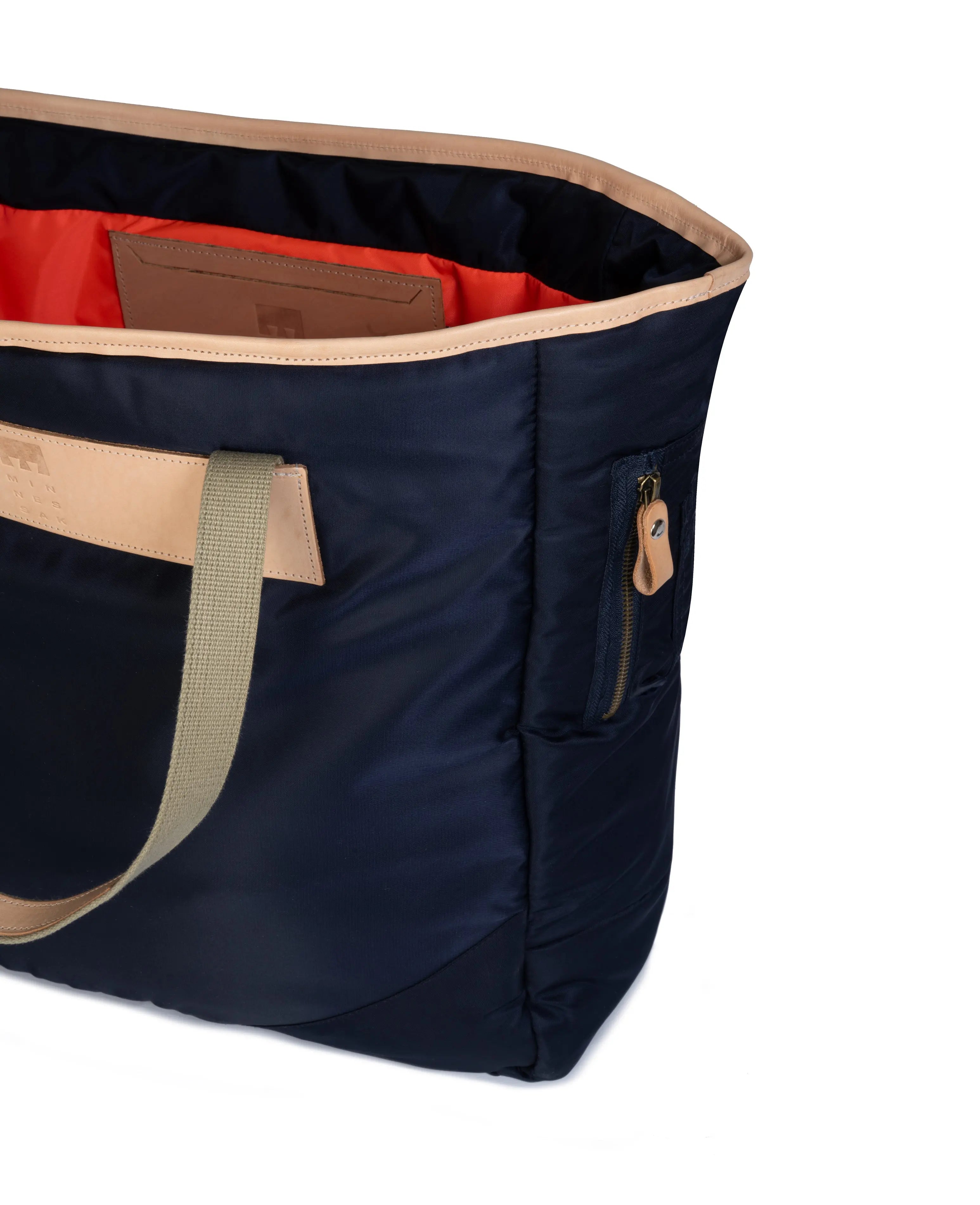 Navy tote bag with olive handles and trim on a white background