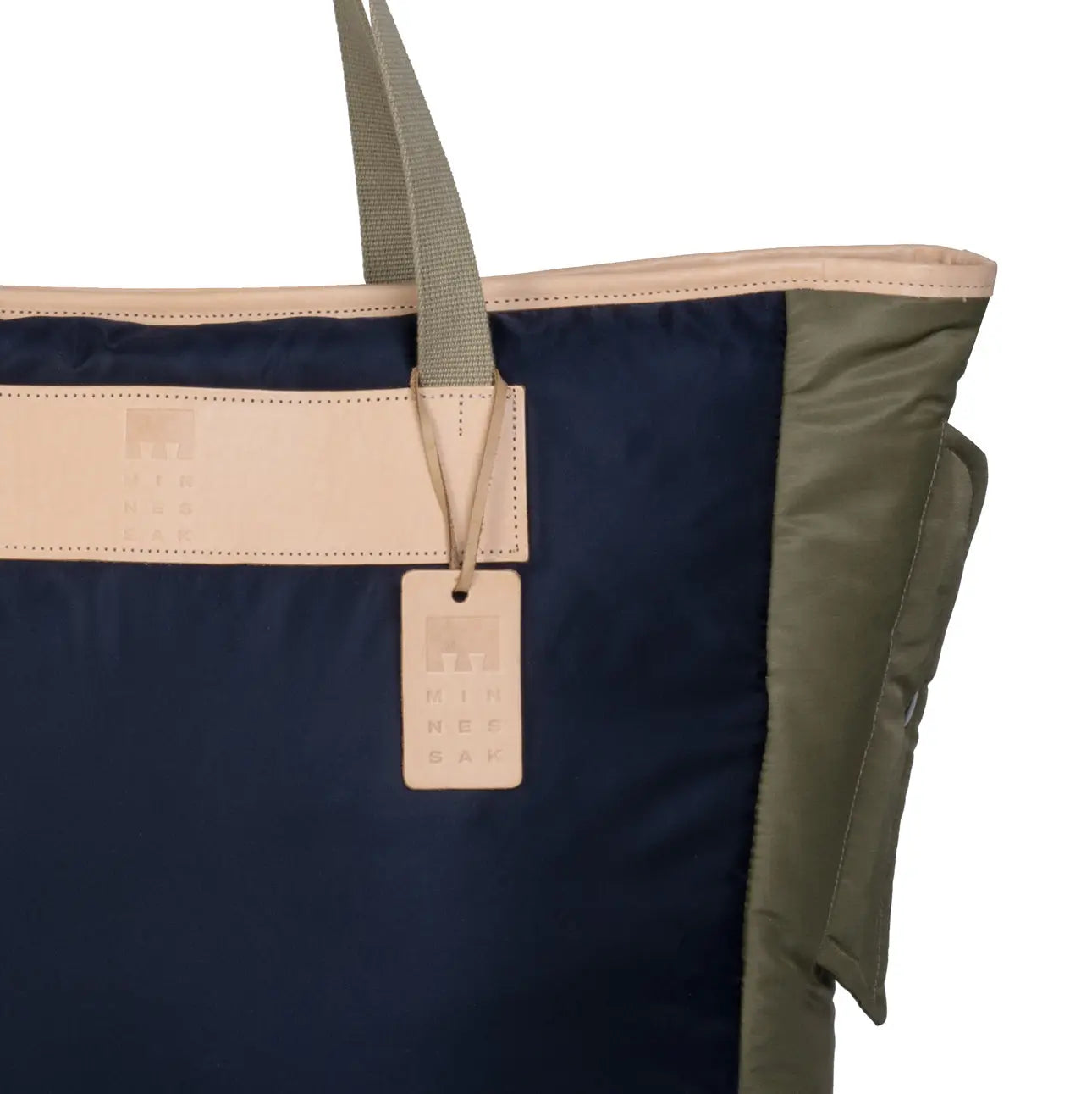 Navy tote bag with beige interior and handle, featuring a brand tag.
