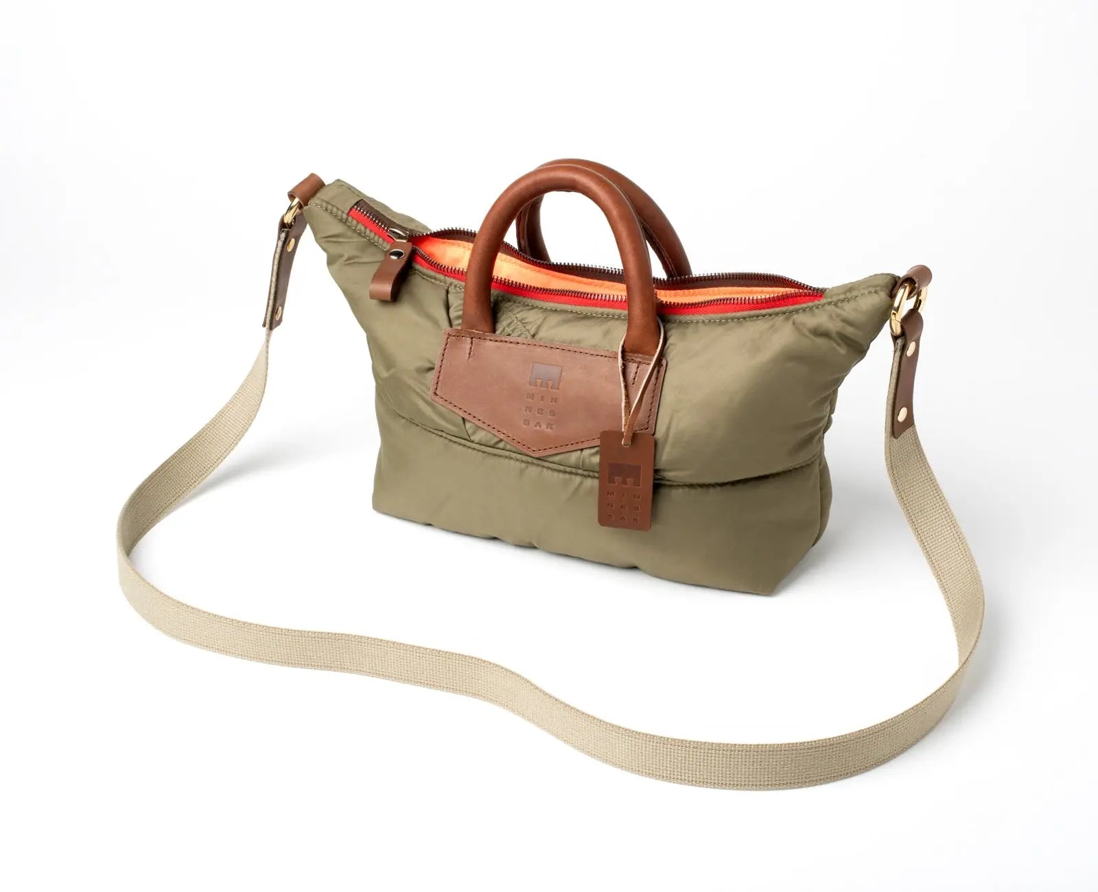 Olive handbag with brown leather accents with strap on a white background