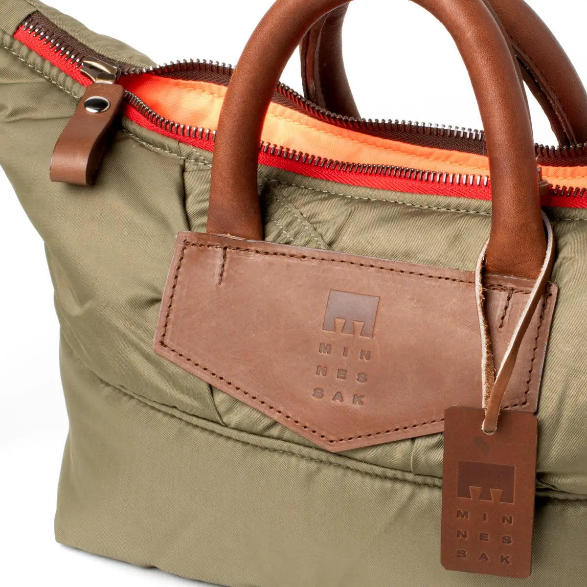 Olive bag with brown leather handles and tag, featuring a visible brand logo.