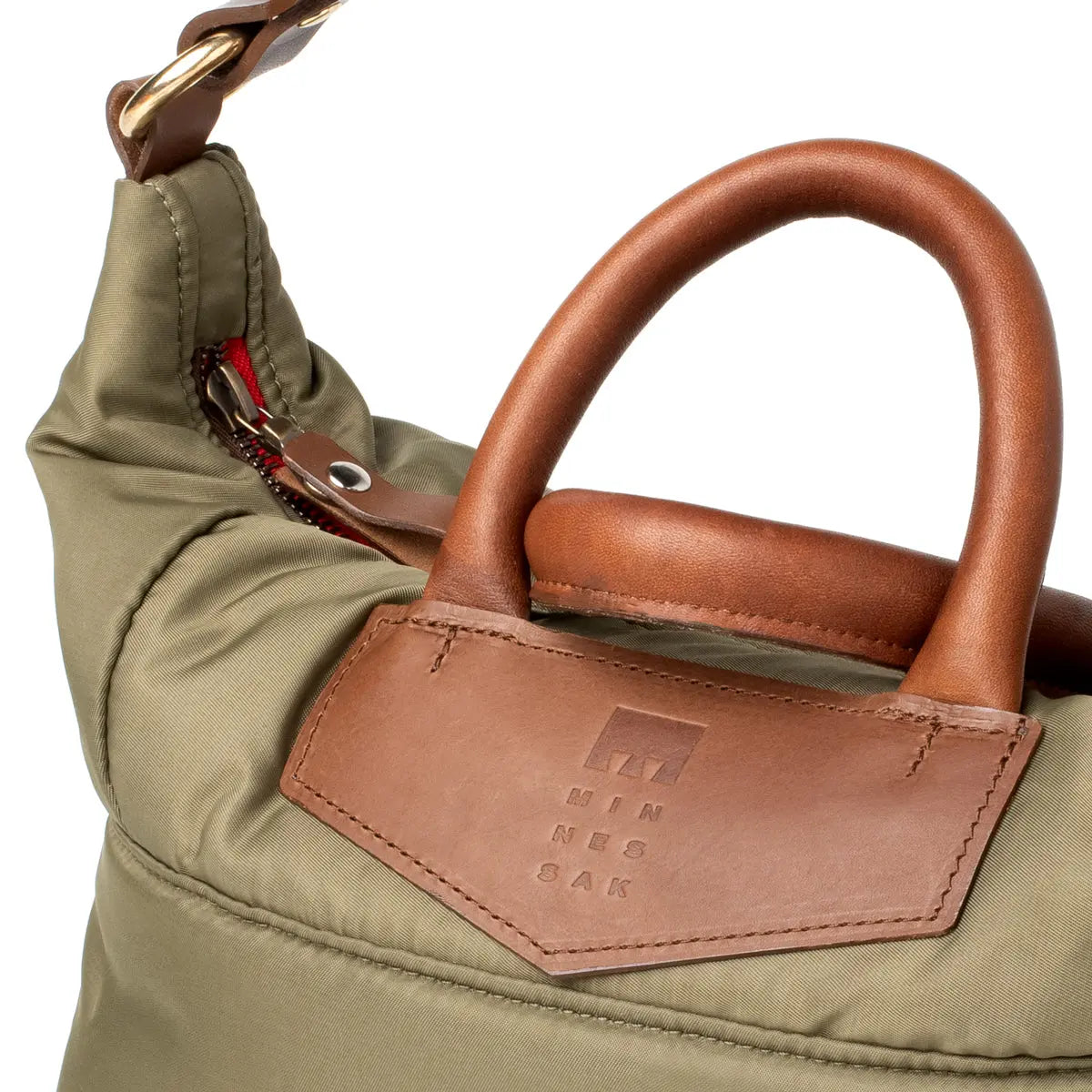 Close-up of an Olive bag with brown leather handle and visible brand logo.