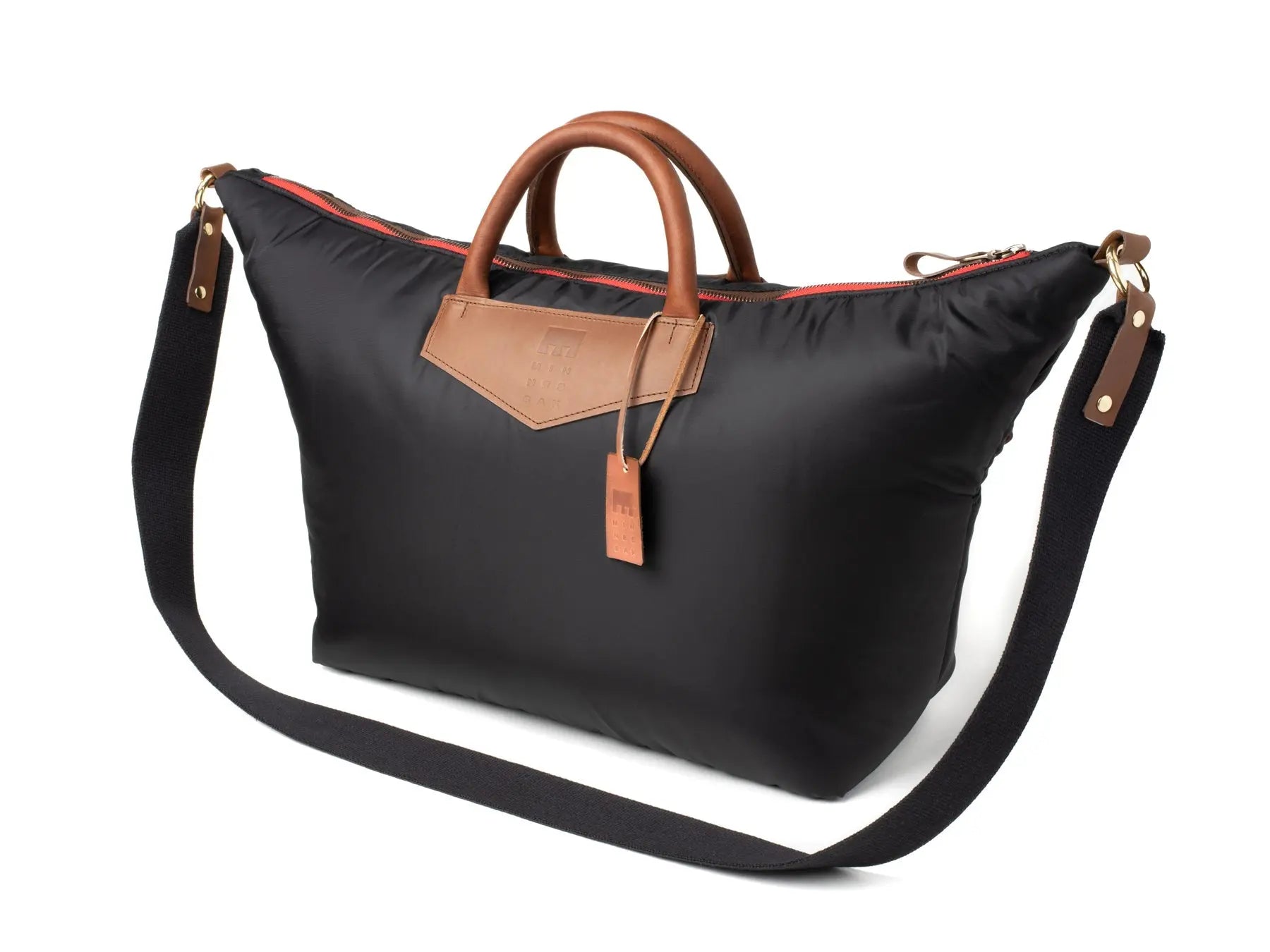 Black bag with brown leather handle and strap on a white background