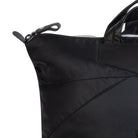 Close-up of a black tote bag with a zipper on a white background