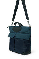 Navy backpack with a black strap on a white background