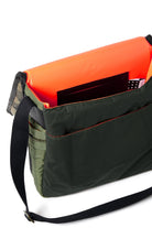 Olive and orange bag with a black strap on a white background