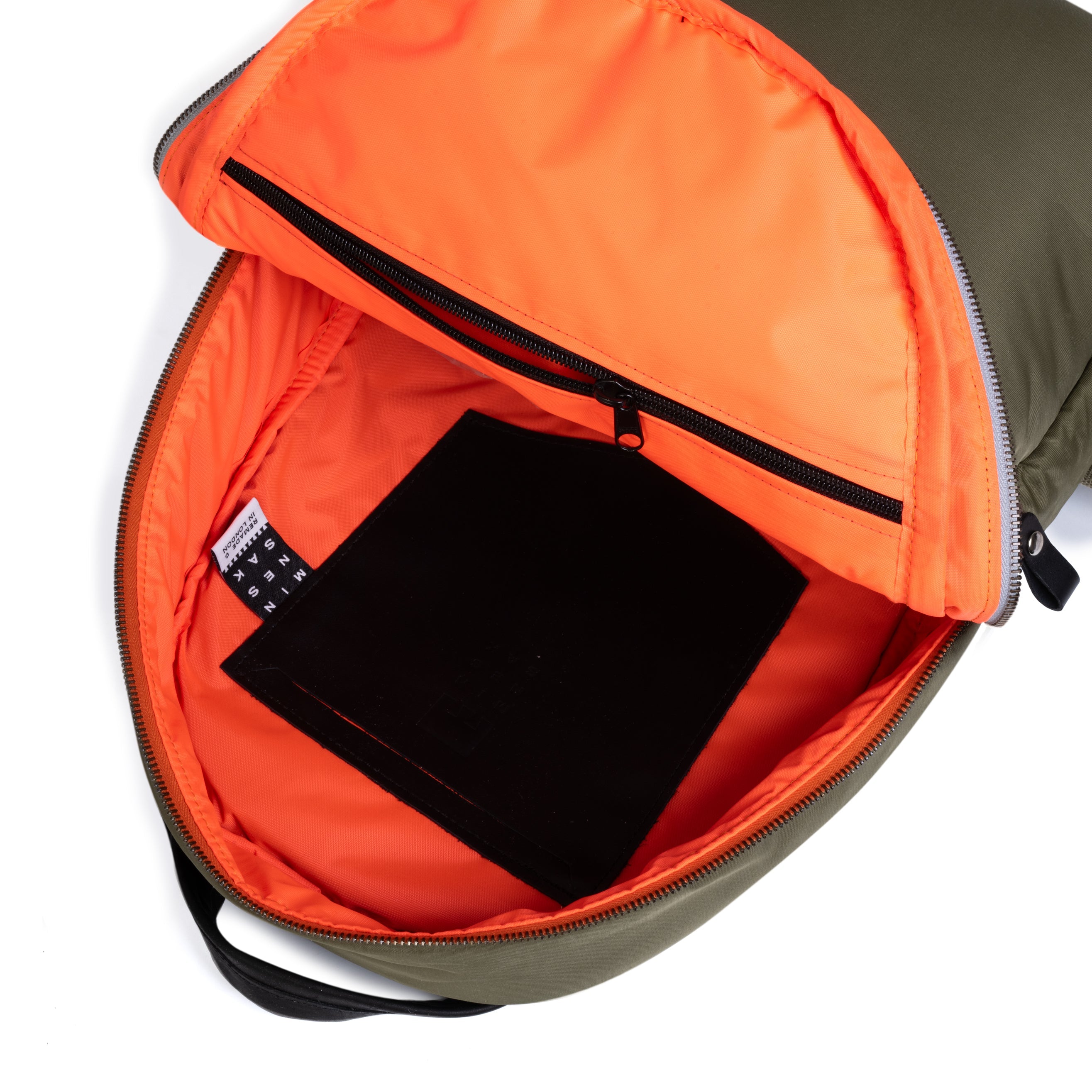 Olive open orange interior backpack with a black item inside on a white background