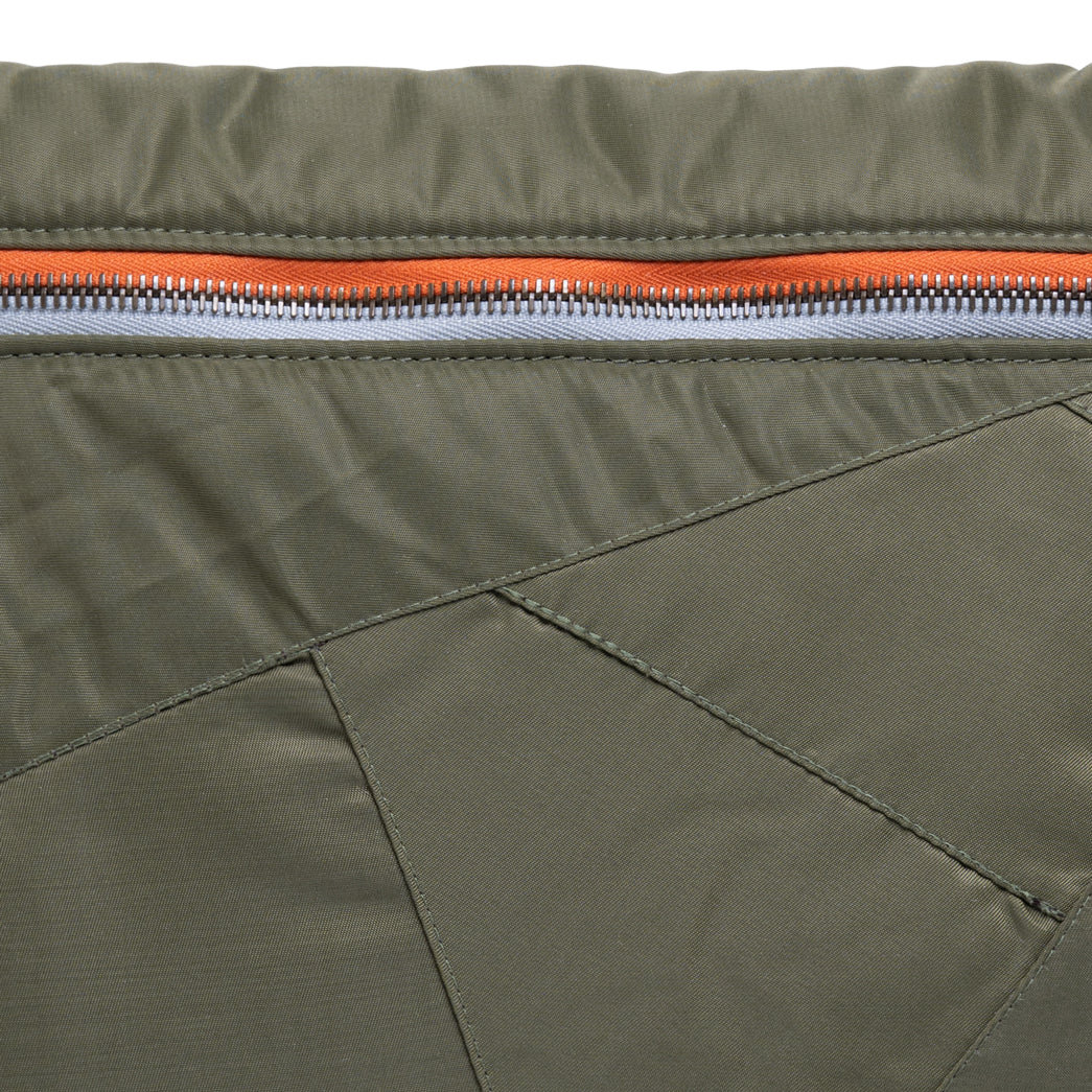 Close-up of a green jacket with an orange zipper