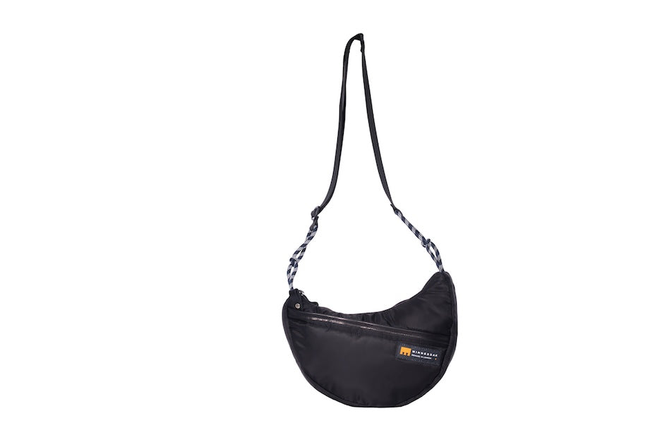 Black Boat Small sustainable crescent crossbody bag handmade from repurposed MA-1 flight jacket material with adjustable shoulder strap and front zip pocket. Front