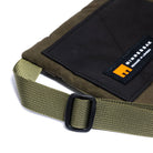 Olive  cross body bag showing strap detail and MInnessak logo on a white background