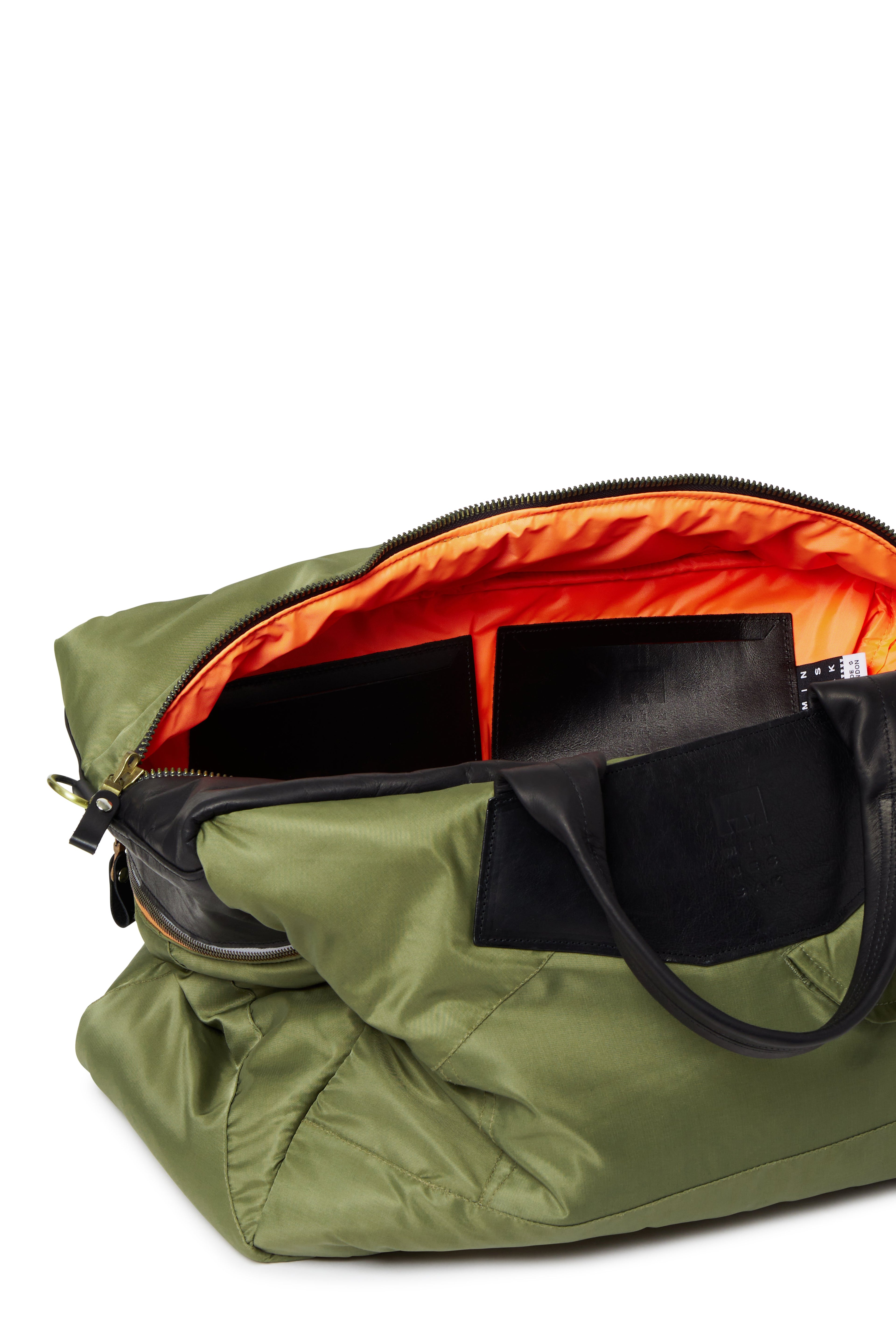 Olive duffel bag with orange interior on a white background