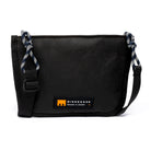 Black shoulder/cross body bag with strap detail and MInnessak logo on white background
