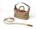 Olive Khaki handbag with brown leather accents and matching strap on a white background